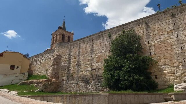 Calle en el barrio antiguo de Zamora con alto muro de piedra y el campanario de la iglesia de san Cipriano, Espa&ntilde;a