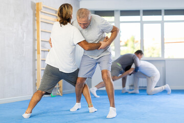 Fototapeta premium Male and senior man sportsman in pair conduct training battle in oriental fighting technique. School of martial arts. Reinforcement strength of mind and body. Sport to max