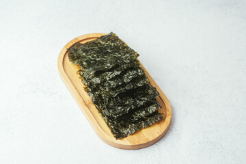 Seaweed snack stacked on wooden tray with white background
