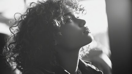 Fototapeta premium Curly Haired Woman Looking Up in Natural Light