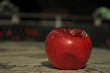 red apple on a table at night