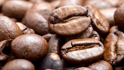 Fresh coffee beans scattered as a background or texture.