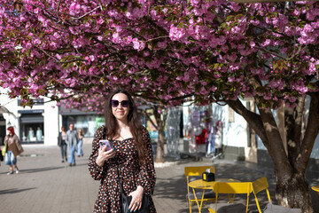 Young woman against the background of a sakura tree