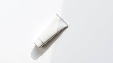 Blank white tube on white background, casting a shadow