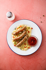 Grilled sausages with couscous and tomato sauce