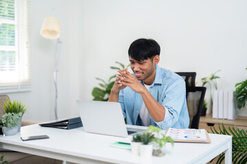 Businessman smiling while video chatting on laptop