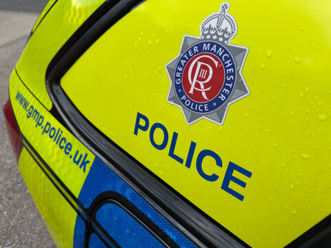 Greater Manchester Police logo and crest on police car with words POLICE
