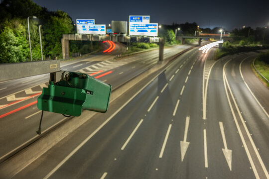 ANPR vehicle surveillance. An ANPR camera on the motorway monitoring traffic flows and speed at night. Light trails of passsing vehicles can be seen,. 