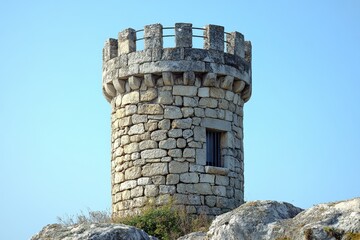 Naklejka premium Majestic Stone Tower against Clear Blue Sky Medieval Architecture Historical Landmark Fortress Medieval Structure