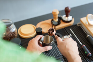 Sustainability and Coffee Preparation. A barista measures coffee beans, aligning with eco-friendly practices in modern coffee making.