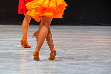 junior girl in a bright orange Latin American dress before the qualifying tournament. Ballroom...