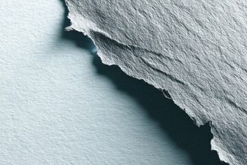 Abstract aerial view of a glacier edge with a contrasting shadow, showcasing the textures and details of the icy landscape and climate change impact.