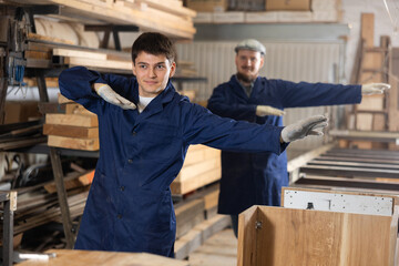Two funny sawmill workers perform various funny acrobatic moves