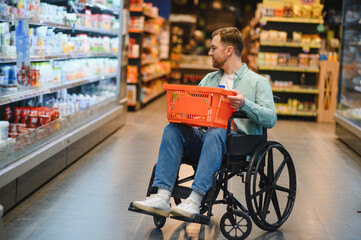 Customer using wheelchair choosing groceries in supermarket