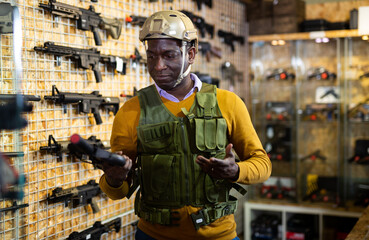 African american man in army uniform with weapon in military market
