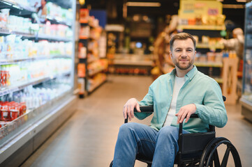 Smiling customer using wheelchair buying groceries in supermarket