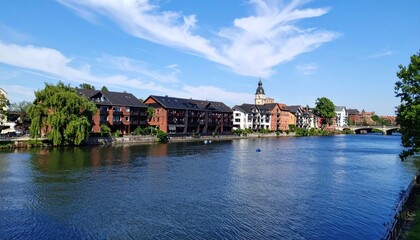Fototapeta premium Picturesque European Riverside Townscape Under a Clear Blue Sky Reflecting in River