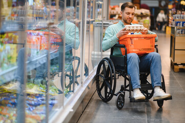 Obraz premium Customer using wheelchair buying groceries in supermarket