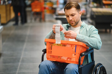 Customer in wheelchair checking grocery receipt in supermarket