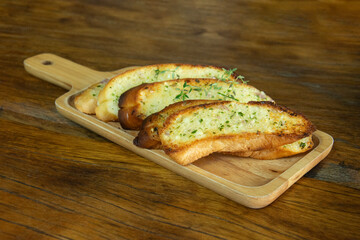 Garlic bread on wooden plate, Cooking concept.