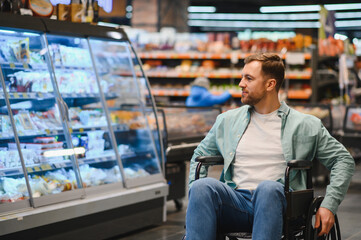 Plakat Customer using wheelchair choosing groceries in supermarket refrigerator