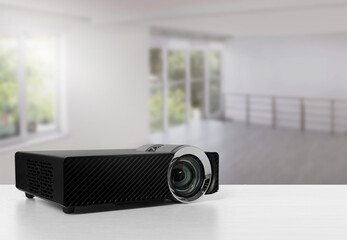 Modern video projector on white table in room