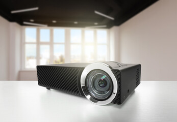 Modern video projector on white table in room