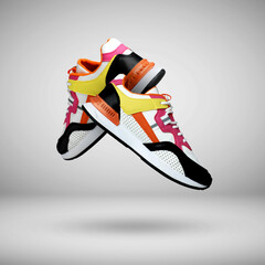 Fashionable sneakers in air on grey gradient background