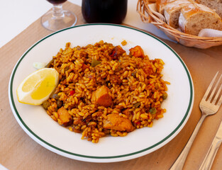 Popular Spanish meat paella with chicken garnished with lemon