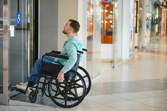Customer exiting elevator in wheelchair at shopping mall