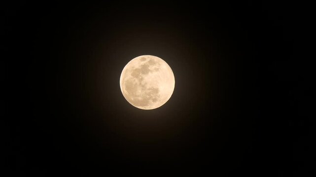 Bright orange and yellow full moon set against dark black sky