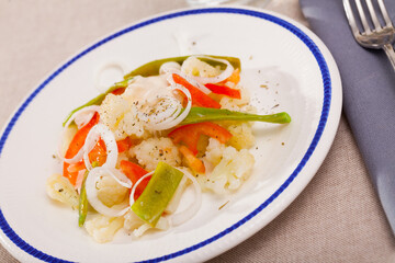 Plate of tasty salad with cauliflower, onion, green beans and bell pepper