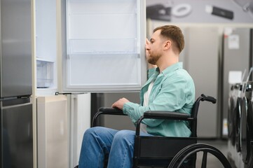 Customer in wheelchair choosing refrigerator in home appliance store