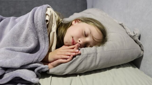 A little girl lies down in bed and tries to sleep, childhood insomnia