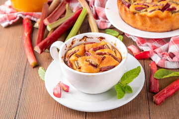 Summer homemade baking, quick microwave made cupcake, mugcake. Simple sweet seasonal dessert recipe, sponge cake with rhubarb slices on top and sweet jam inside