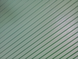 Diagonal Green Wooden Panel Texture. 
A close-up view of diagonally arranged green-painted wooden...