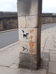 Urban pillar adorned with stencil art designs.