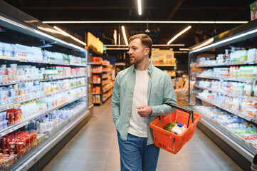 Customer choosing groceries walking through supermarket aisles