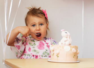 Two year old girl eats birthday cake