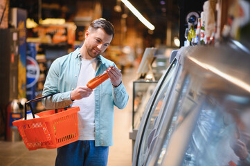 Customer choosing products in supermarket refrigerator section