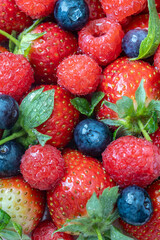 Fresh Strawberries, Raspberries, Blueberries, and Mint Leaves Arranged in a Colorful and Natural Composition