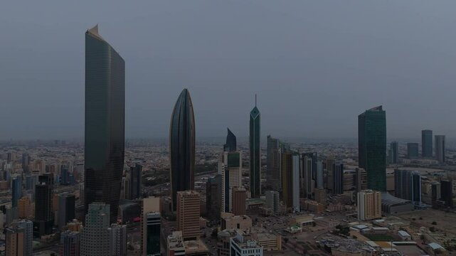 Dramatic 4K aerial shot of Kuwait&rsquo;s skyline on a cloudy day. Modern towers and dense urban landscape&mdash;ideal for documentaries, real estate, and cinematic city visuals.
