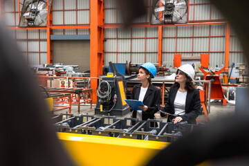 Two female industrial engineers working in manufacturing industry factory