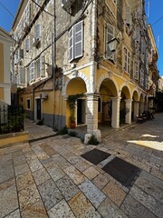 Fototapeta premium Golden hour view of Corfu Town (Kerkyra) on the island of Corfu, Greece. Warm sunlight bathes the historic buildings, narrow streets, and coastal architecture, highlighting the charm of this Mediterra