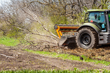 Picture of a tractor specialized in forest clearing that is in the process of destroying all the...