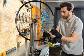 Mechanic in black gloves adjusting wheel