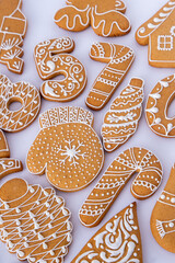 Gingerbread decorated with white sugar glaze. Food background. Christmas tree cookies. Winter holiday shape