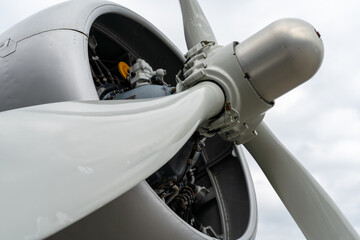 Closeup of engine of older propeller airplane against a cloudy sky. Selective focus.