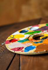 multicolored paint palette sitting on top of a wooden table