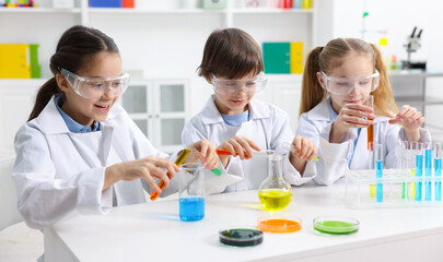 Children doing chemical experiment at desk indoors